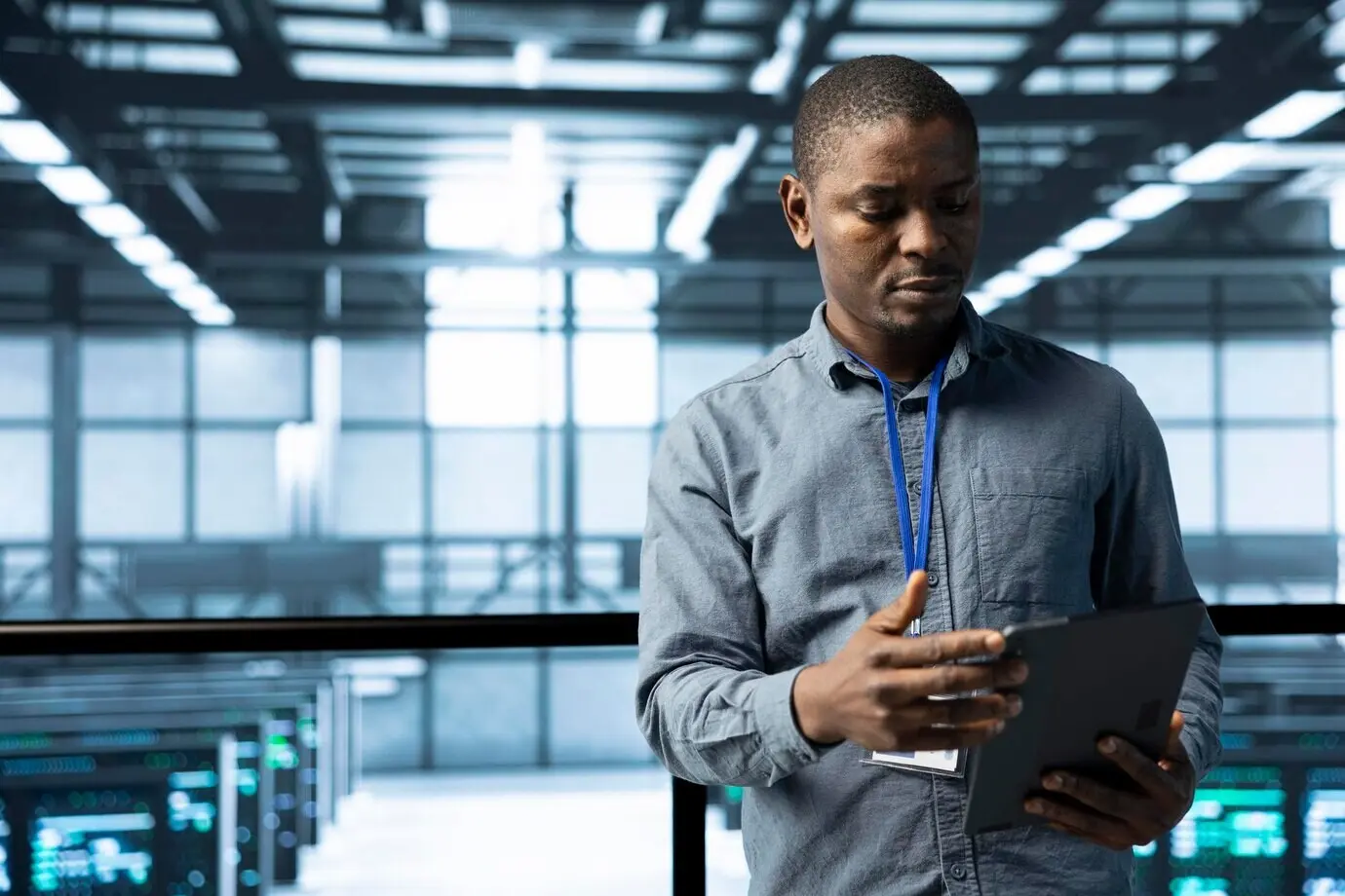 Un científico de la computación en un centro de datos utiliza una tableta para verificar la conformidad de los racks.