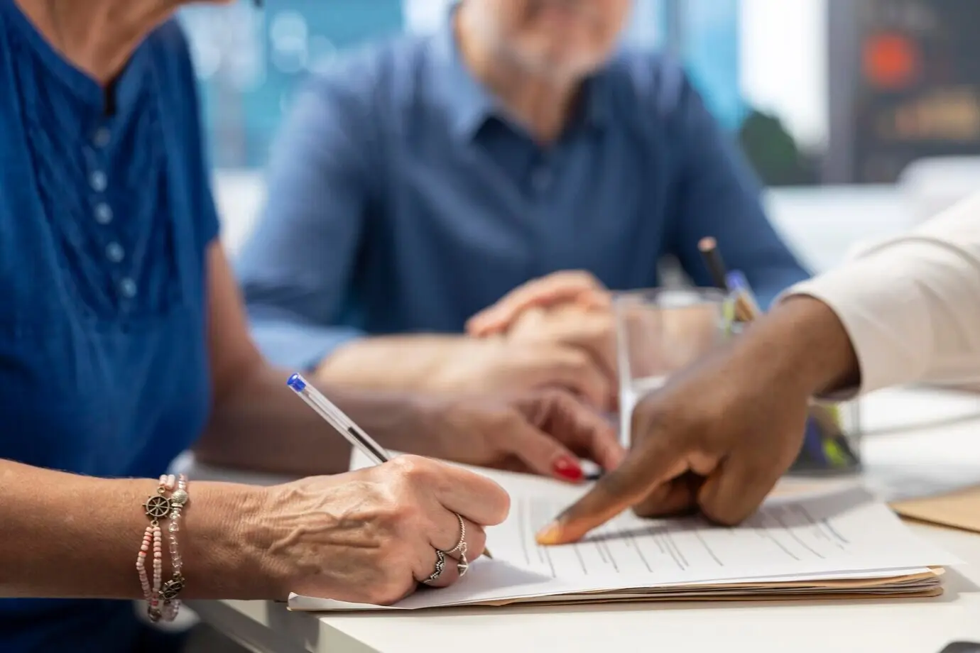 Mujer de mediana edad firmando un contrato de plan de jubilación para asegurar sus ingresos futuros